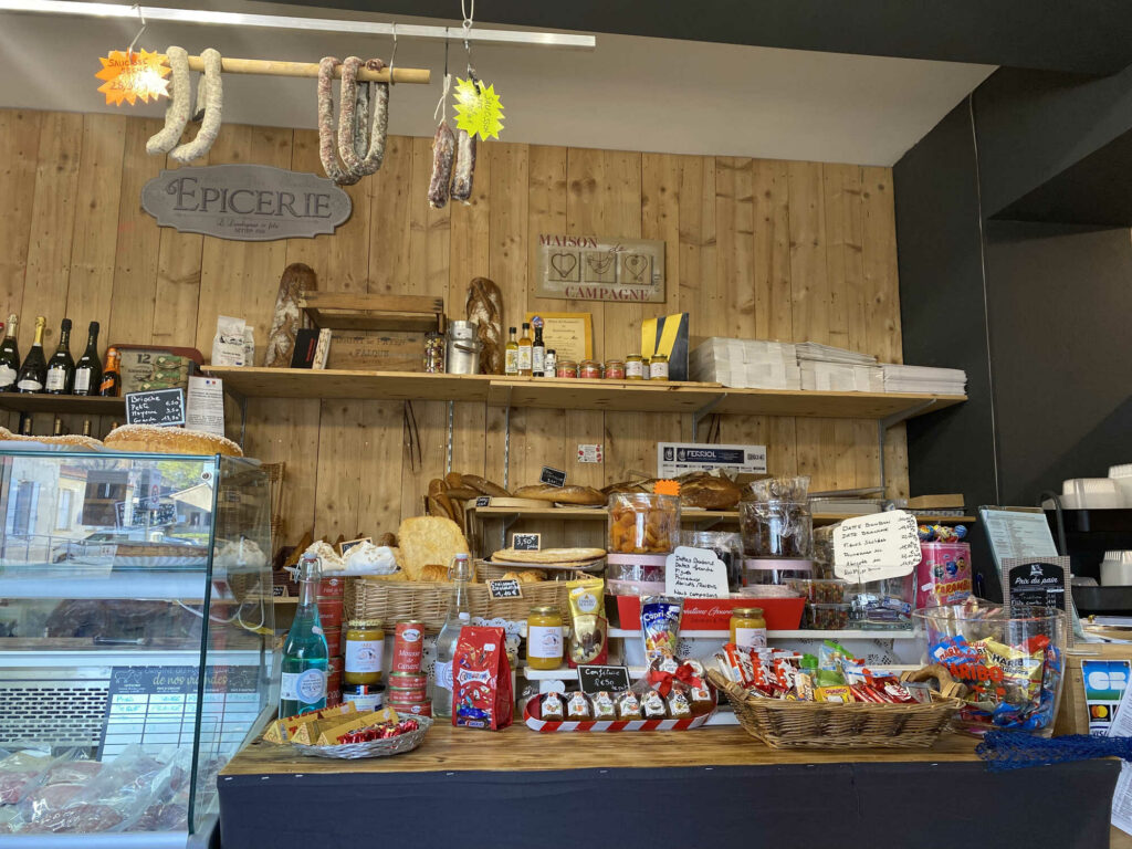 épicerie audelices-de-july à Castelnaudary avec produits artisanaux, saucissons, vins et sucreries sur étagères en bois,